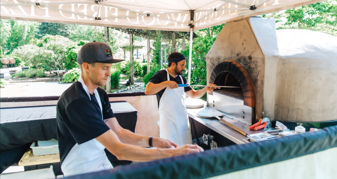 Avella, owner and staff working a pizza oven